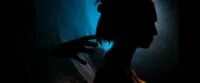 A close up shot of a woman's silhouette in profile as a sinister hand reaches for her head in The People in the Walls.