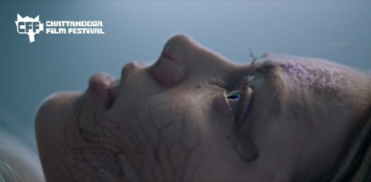 Side profile of a woman's face, facing up from a lying down position, with a darkness growing in her veins