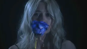 A woman holding a blue rose