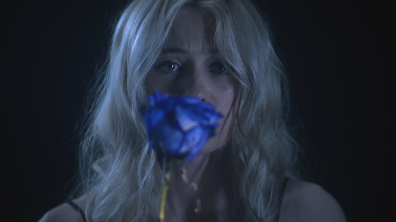 A woman holding a blue rose