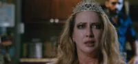 A woman wearing a crown and looking distressed
