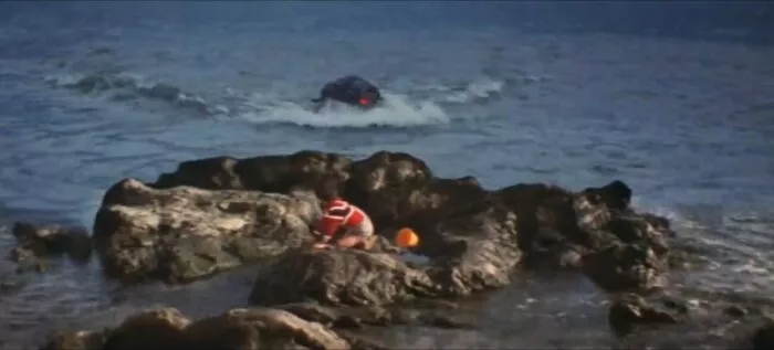 Hedorah emerges from the ocean and attacks a small boy