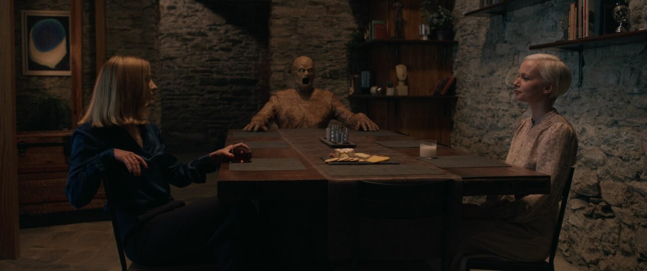 Two women at a table with a wooden mannequin