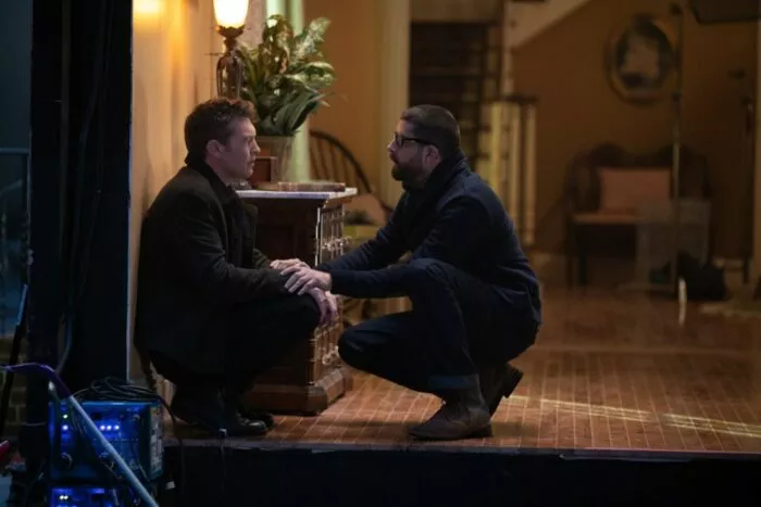 Two men crouching down and talking
