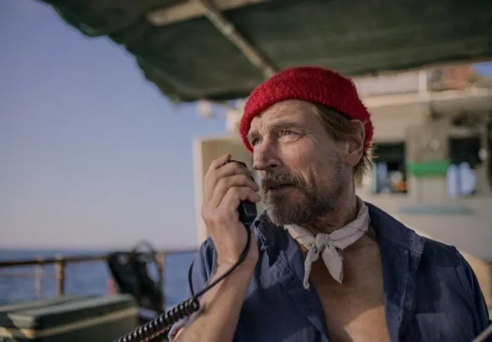 A man talking on a ship radio