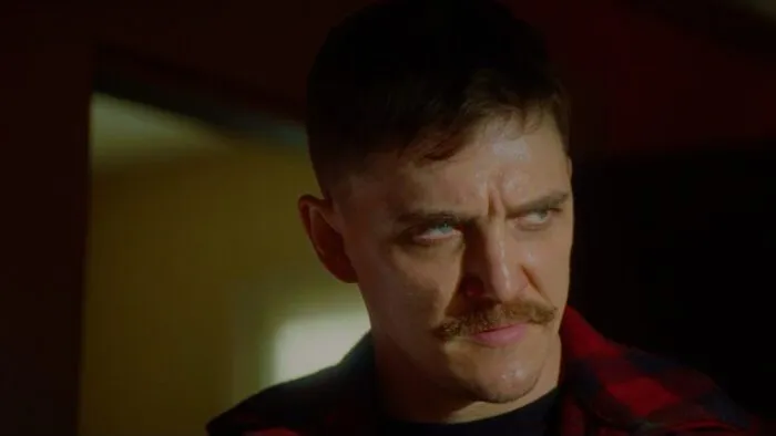 A sneering man with a mustache.