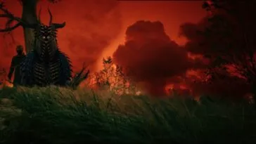 A man standing by a tree next to a strange being under a red skyd