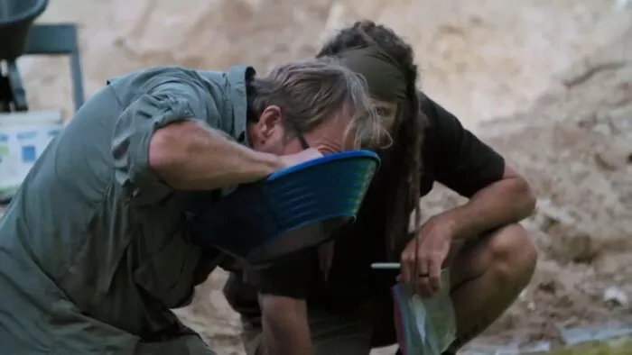 Eric peers into his pan while Chad watches on 