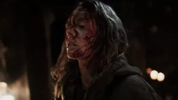 A woman with a bloodied face projects strength.