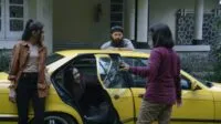 People standing around a car and talking