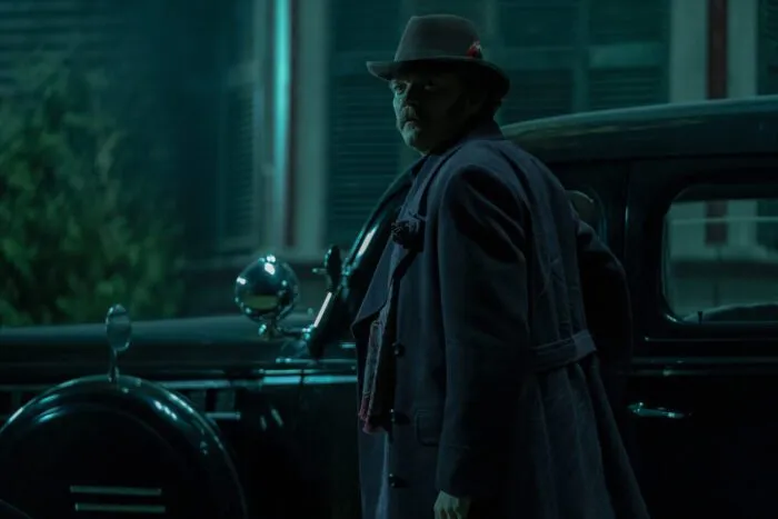 A man standing outside a car at night