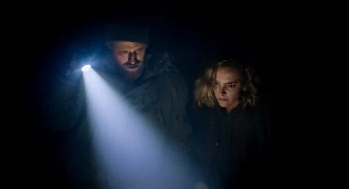 Two people in the dark with a flashlight
