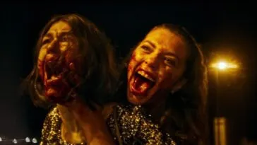 Two women with bloody faces screaming while on a motorcycle
