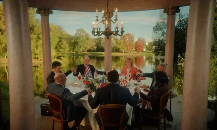 World leaders sitting at a table and holding hands