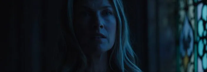 A woman looks haunted in a soft blue light