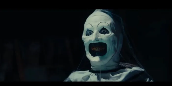 Art the Clown covered in cob webs and smiling