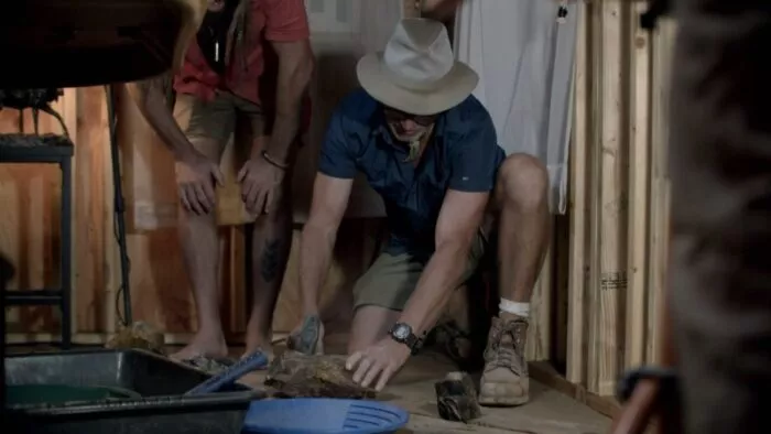 Eric Drummond hammers one of the rocks as Chad stands over and watches