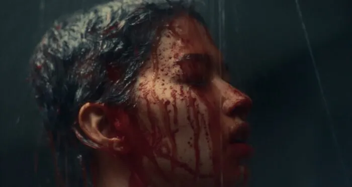 A woman washing blood off her face