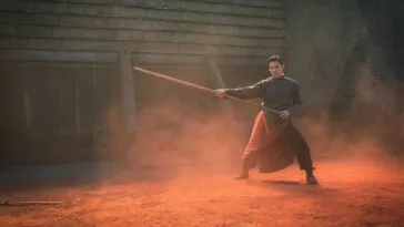 A man doing martial arts with a stick