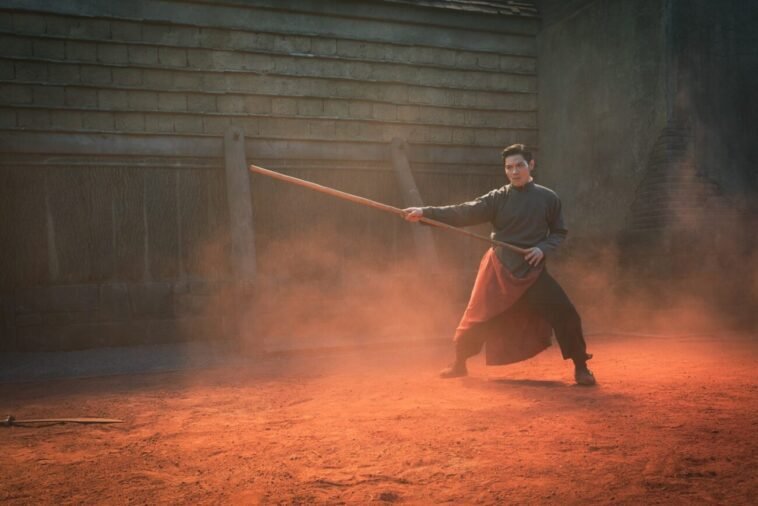 A man doing martial arts with a stick