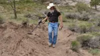 Charlie Snider holds a metal detector at Bead Site.
