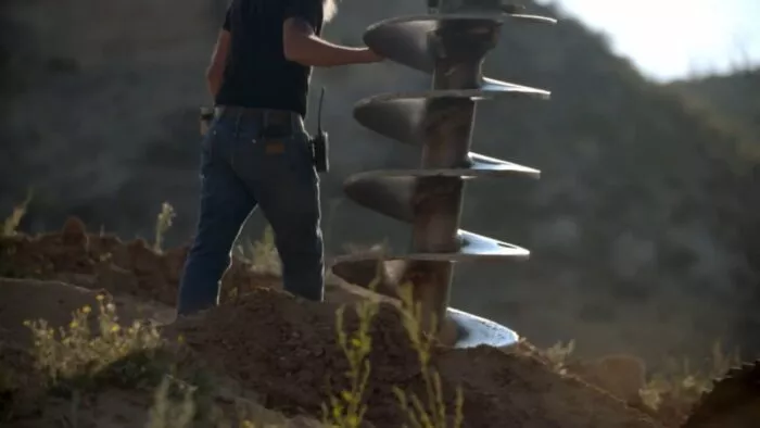 Charlie Boy stands next to the rathole rig's auger bit