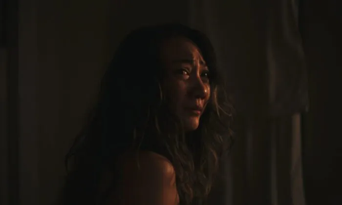 A distraught woman looks over her shoulder in BLEEDING