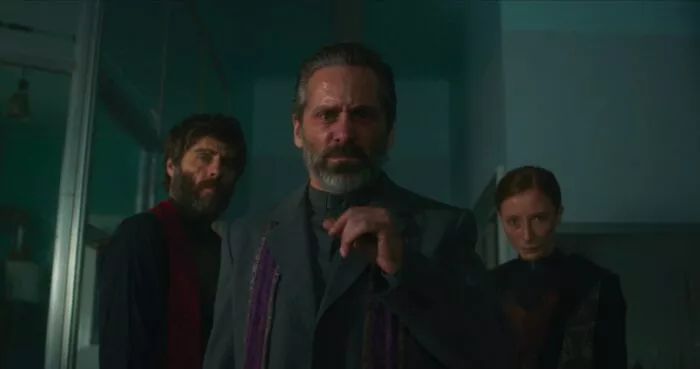 A priest holds his hand up in caution while a priest and nun stand behind him in Deus Irae