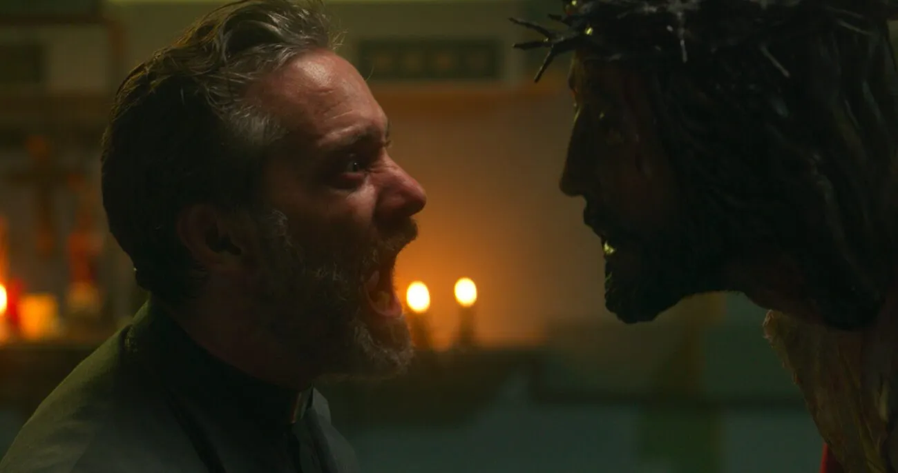 A man screams looking into a Jesus mask on another person.