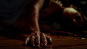 a body laying in a pool of blood with it's arm outstretched.