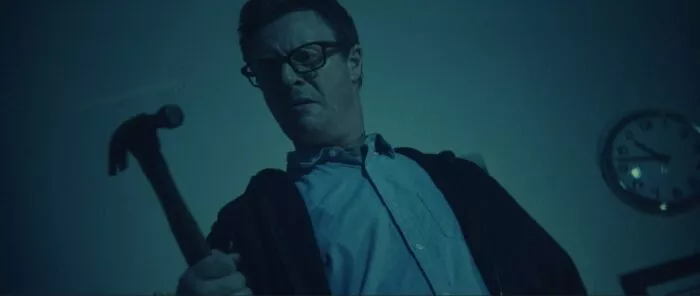 A man examines the hammer he's holding