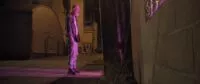 A man in an alley stares into a purple light