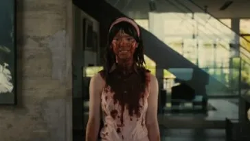 A woman stands covered in blood from her head to her naval in COMPANION