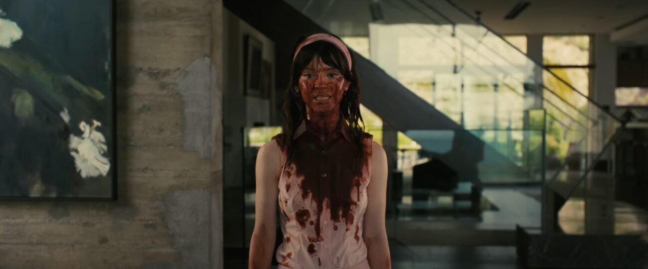 A woman stands covered in blood from her head to her naval in COMPANION
