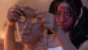 A woman with a bloody face holds up the flesh of someone else's face in GRAFTED