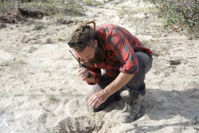 At the Bead Site bore hole, Chad Ollinger radios over to the Pond to alert the rest of the team that the acoustic homing beacon has been deployed into the underground waterway