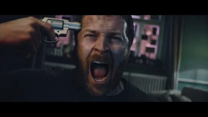 A man aiming a gun at his head is screaming