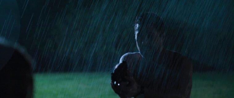The silouette of a man holding a gun in the rain of WHEN IT RAINS IN LA