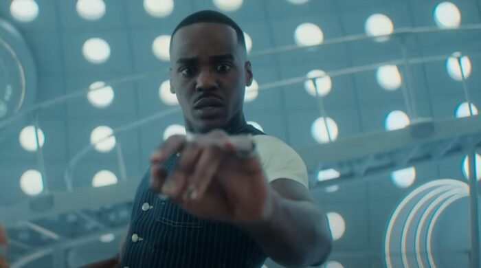 Actor Ncuti Gatwa as Doctor Who looking at his hand from within a space ship. 