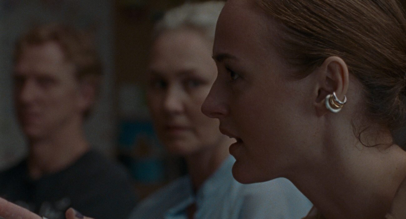 A man and a woman stare at another woman who is speaking straight ahead in ARMAND.