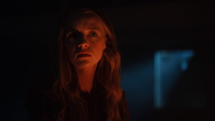 A woman seen in low light while in a dark room