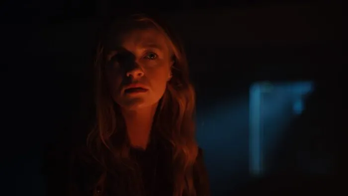 A woman seen in low light while in a dark room