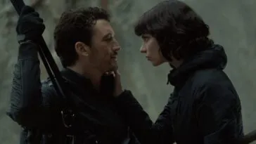 A man holding on to a rope gazes into the eyes of the woman touching his face