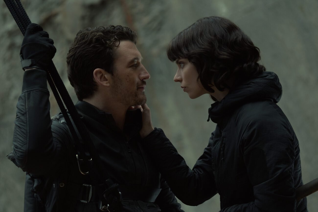 A man holding on to a rope gazes into the eyes of the woman touching his face