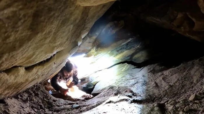 Chad climbs in the small opening noticed by Duane.