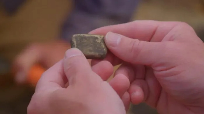 James holds the slag ingot in his hands.