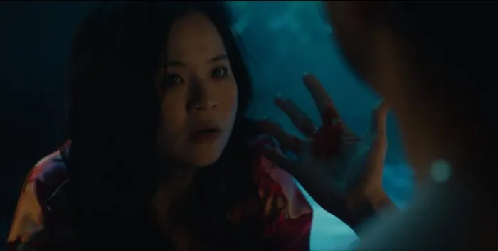 A woman stares at another woman who is looking at the blood in her hand.