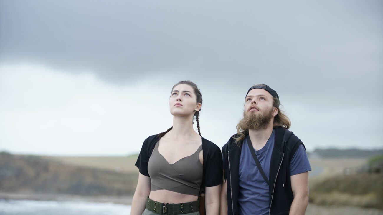 A woman and a man look up at the gray sky.