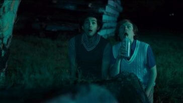 Two young men look surprised as one sips a drink