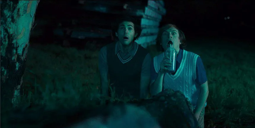 Two young men look surprised as one sips a drink